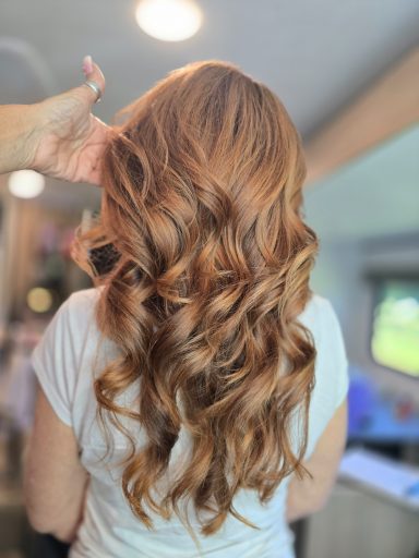Long, wavy copper hair styled elegantly, viewed from behind.