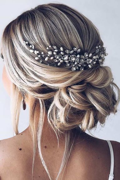 Elegant updo hairstyle adorned with a jeweled hairpiece.